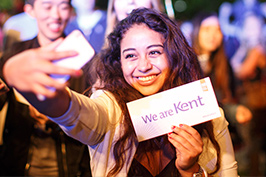 Kent student taking a selfie with a We are Kent sign